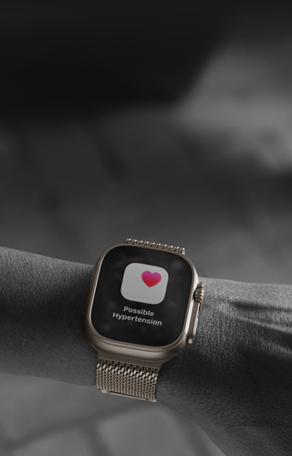 Eine Person trägt die Apple Watch Ultra 3 am Handgelenk, Hinweis zur Gesundheit auf dem Display: Möglicher Bluthochdruck