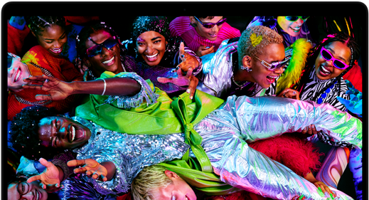 Buntes Display eines MacBook Pro mit einer Person, die bei einer Party durch die Menge getragen wird, verdeutlicht die Brillanz des Liquid Retina XDR Displays