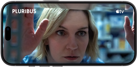 Ein iPhone 18 Pro im Querformat, das Display zeigt eine Nahaufnahme einer Frau, die aus einem Fenster schaut. Serienname: Pluribus