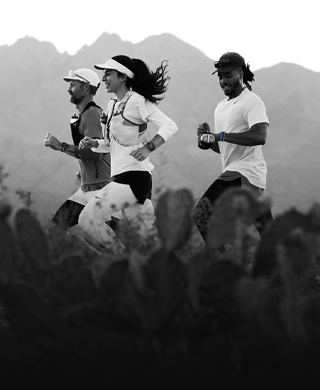 Drei Personen laufen in einer Berglandschaft, alle tragen die Apple Watch Ultra 3