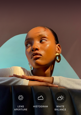 Nahaufnahme eines gut beleuchteten Models mit einem bunten Hintergrund, das das Pro Kamera-System mit der Pro Steuerung zeigt: Blende, Histogramm, Weißabgleich